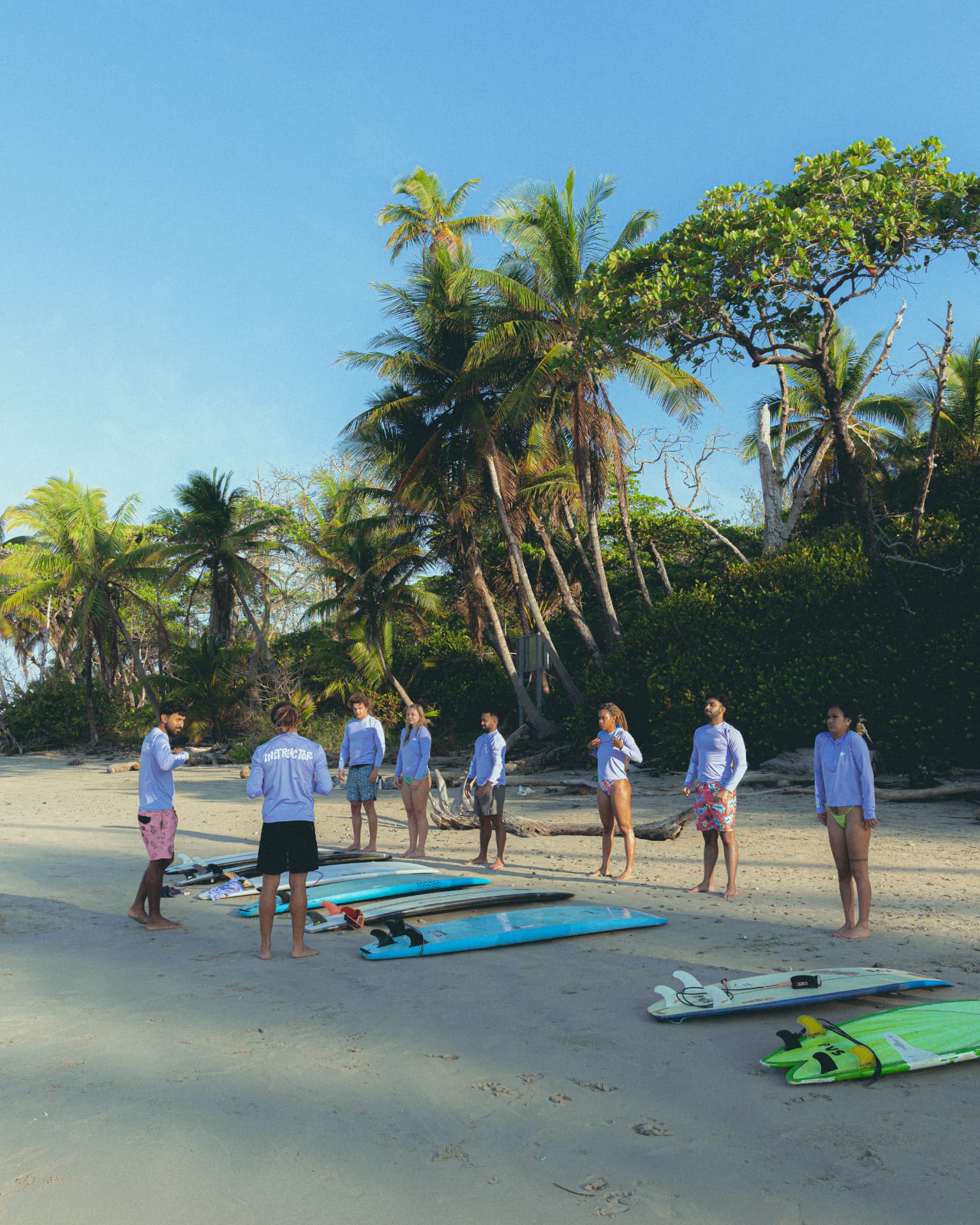 Group briefing with boards laid out on the beach